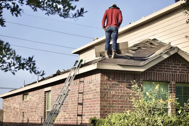 Professional roofer working on a residential roof in Stoughton